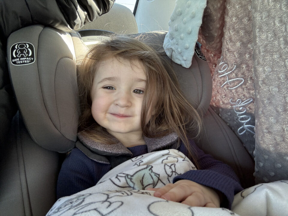 Olivia in her carseat making a funny face