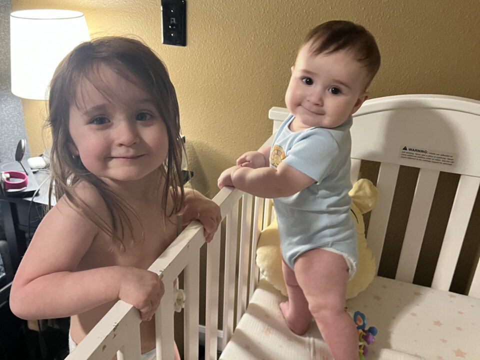 Olivia and Jack beside Jack's crib