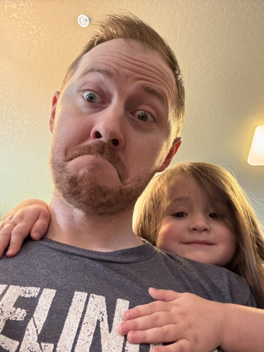 Olivia hugging Jon from behind his shoulders